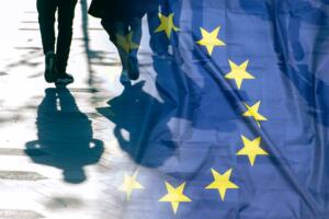 Bandera de la UE con personas al fondo.